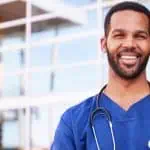 smiling male nurse outside of a hospital building