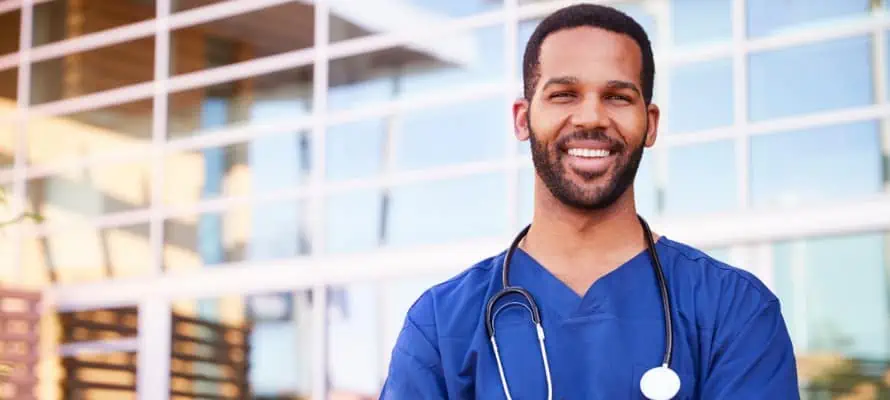 smiling male nurse outside of a hospital building