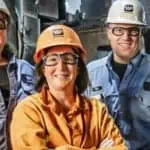 three waupaca foundry employees standing outside of a plant