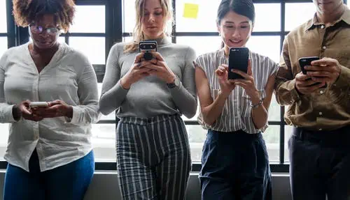 four people on their mobile phones