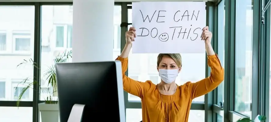 businesswoman wearing a medical mask holding up sign