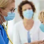 doctor checking a little boy's heart