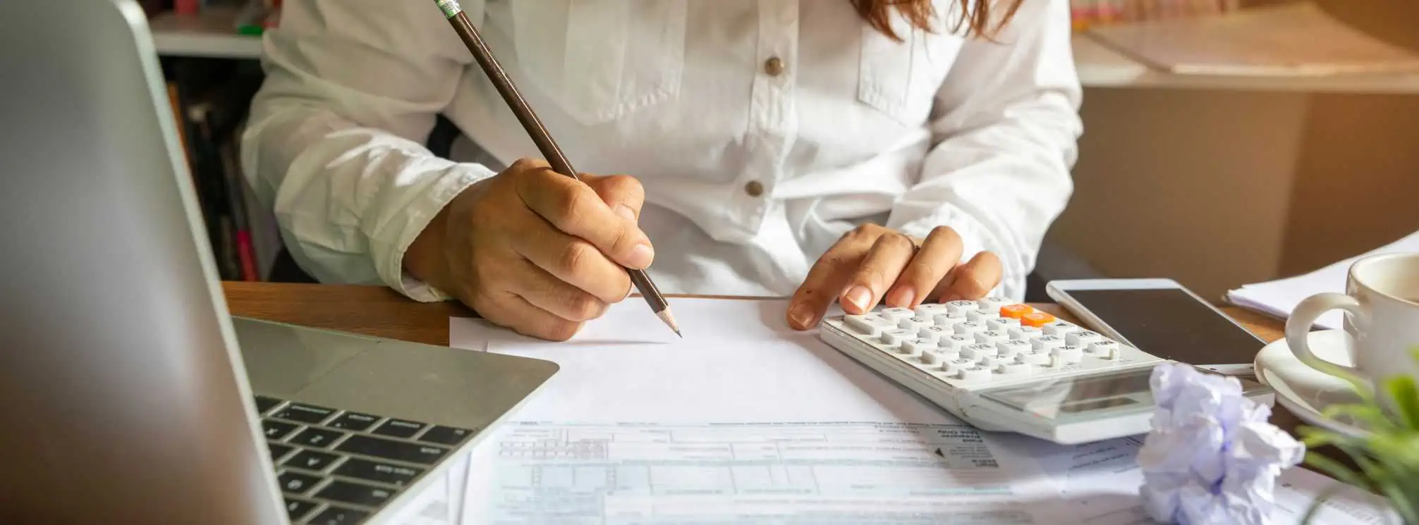 female professional writing on a budget sheet and using a calculator