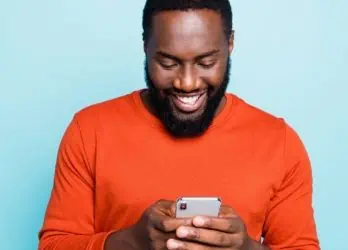 Smiling man using his mobile phone