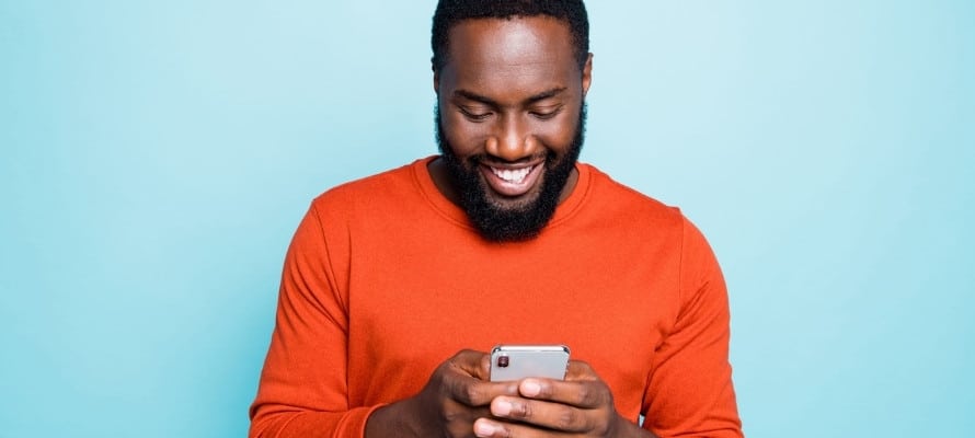 Smiling man using his mobile phone