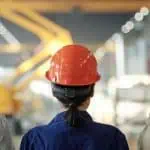 manufacturing workers facing away wearing hard hats