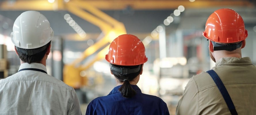 manufacturing workers facing away wearing hard hats