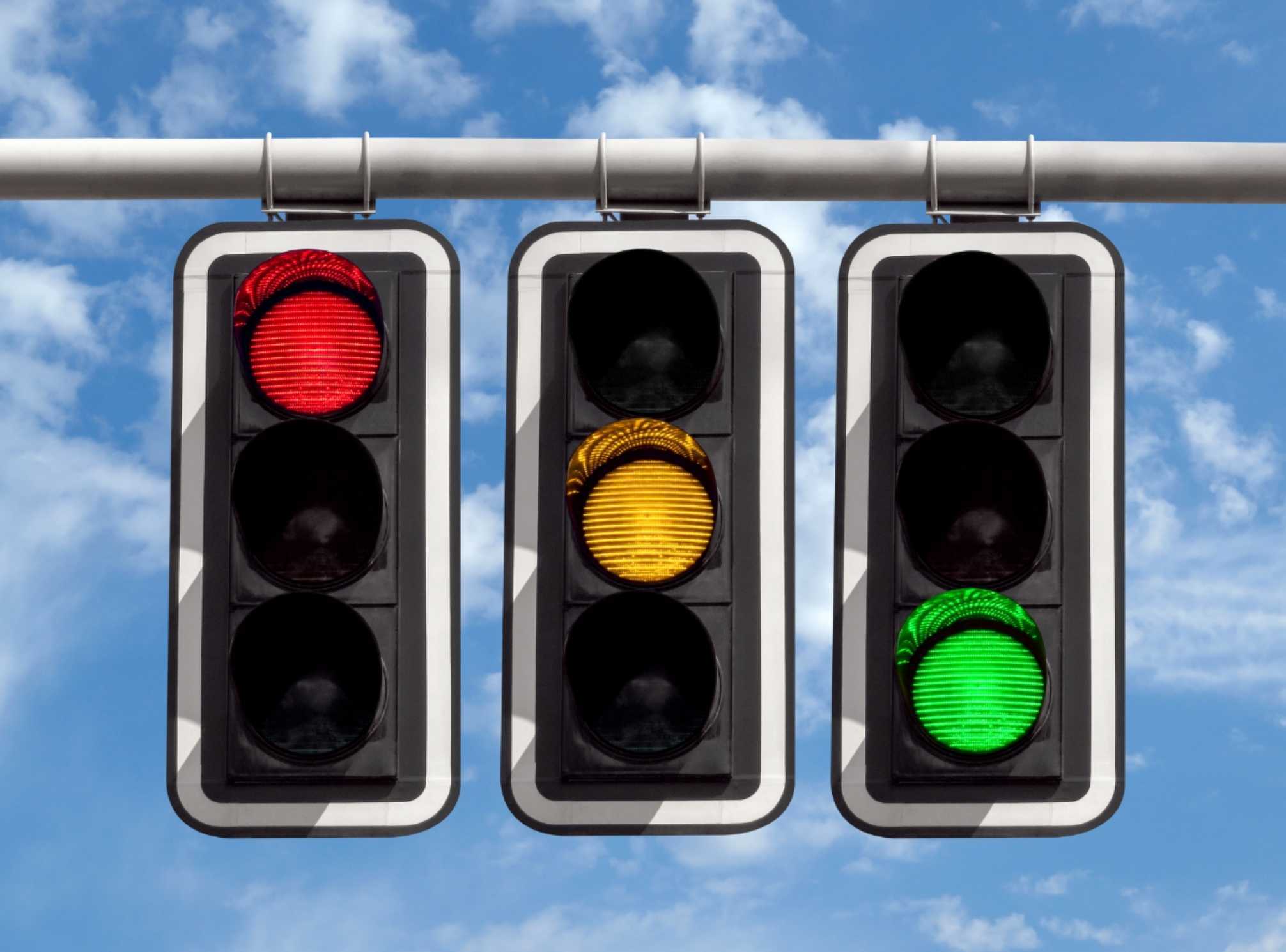 3 traffic lights, one red, one yellow, and one on green