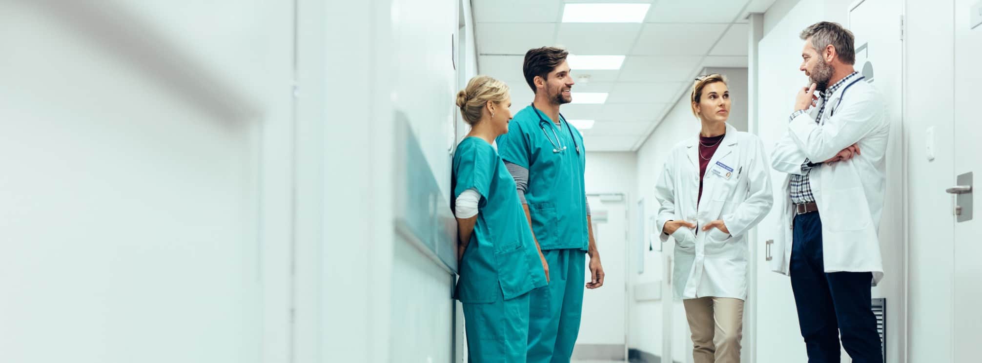 physician leading a team huddle with his hospital staff