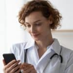 female doctor using a smartphone to view internal communications