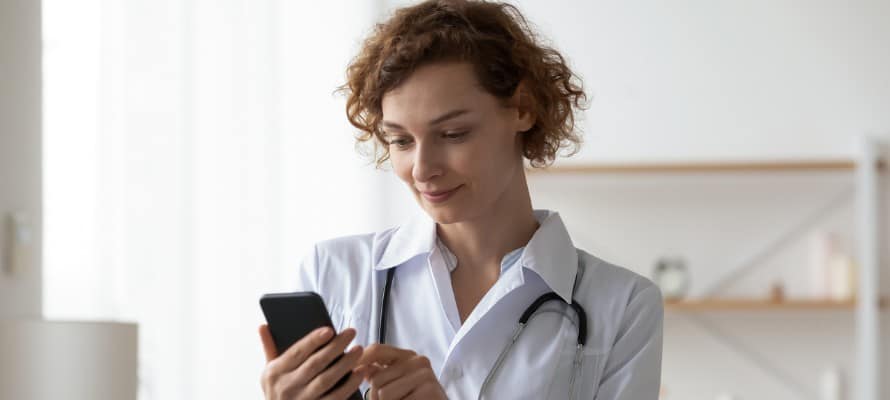 female doctor using a smartphone to view internal communications