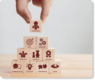 Wooden blocks being stacked into a pyramid with the top block being placed labeled "leadership" to represent an internal executive communications plan