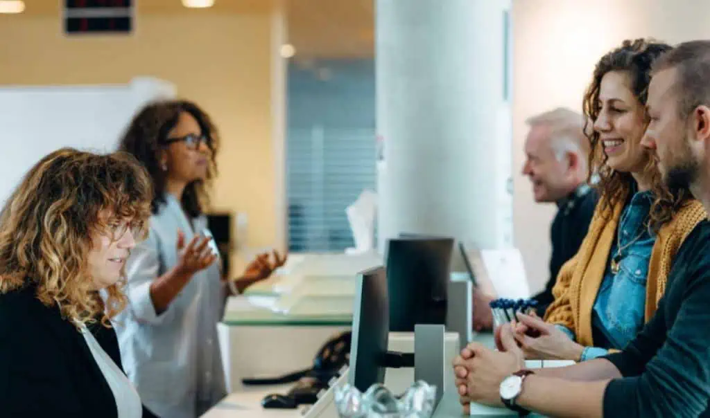 people talking to a government employee behind a desk