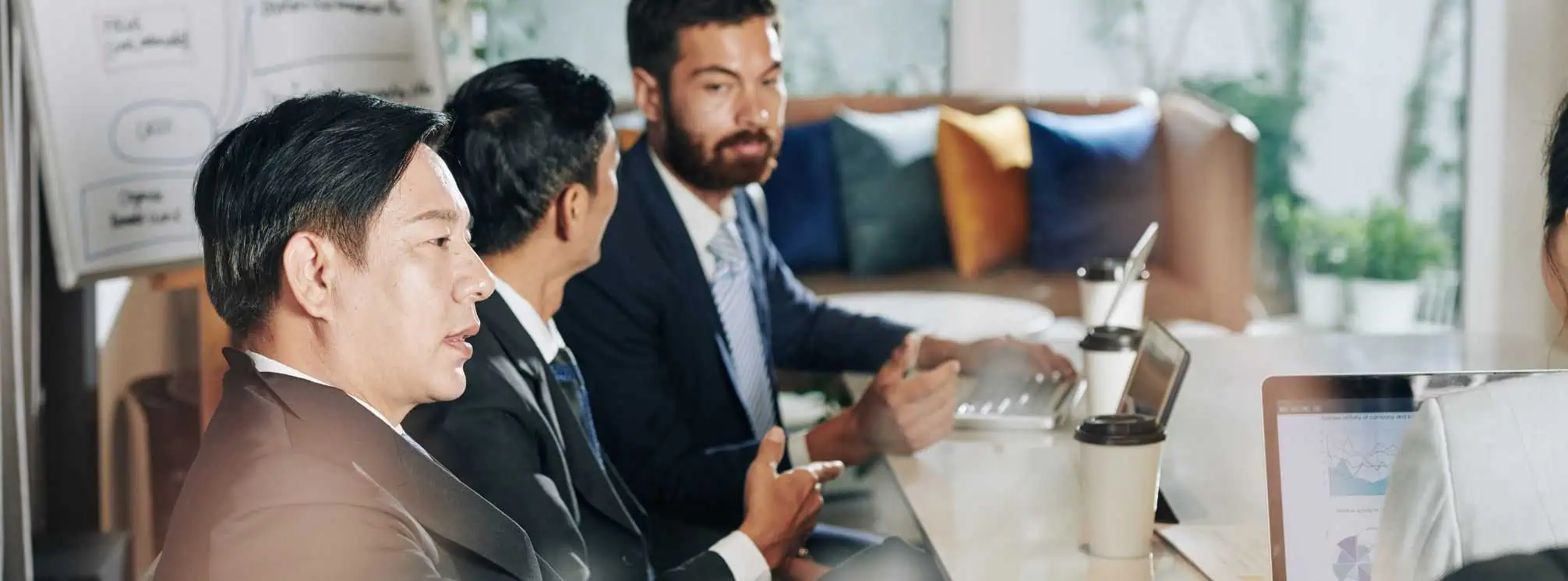 stakeholder meeting with three professionals sitting next to each other in a conference room