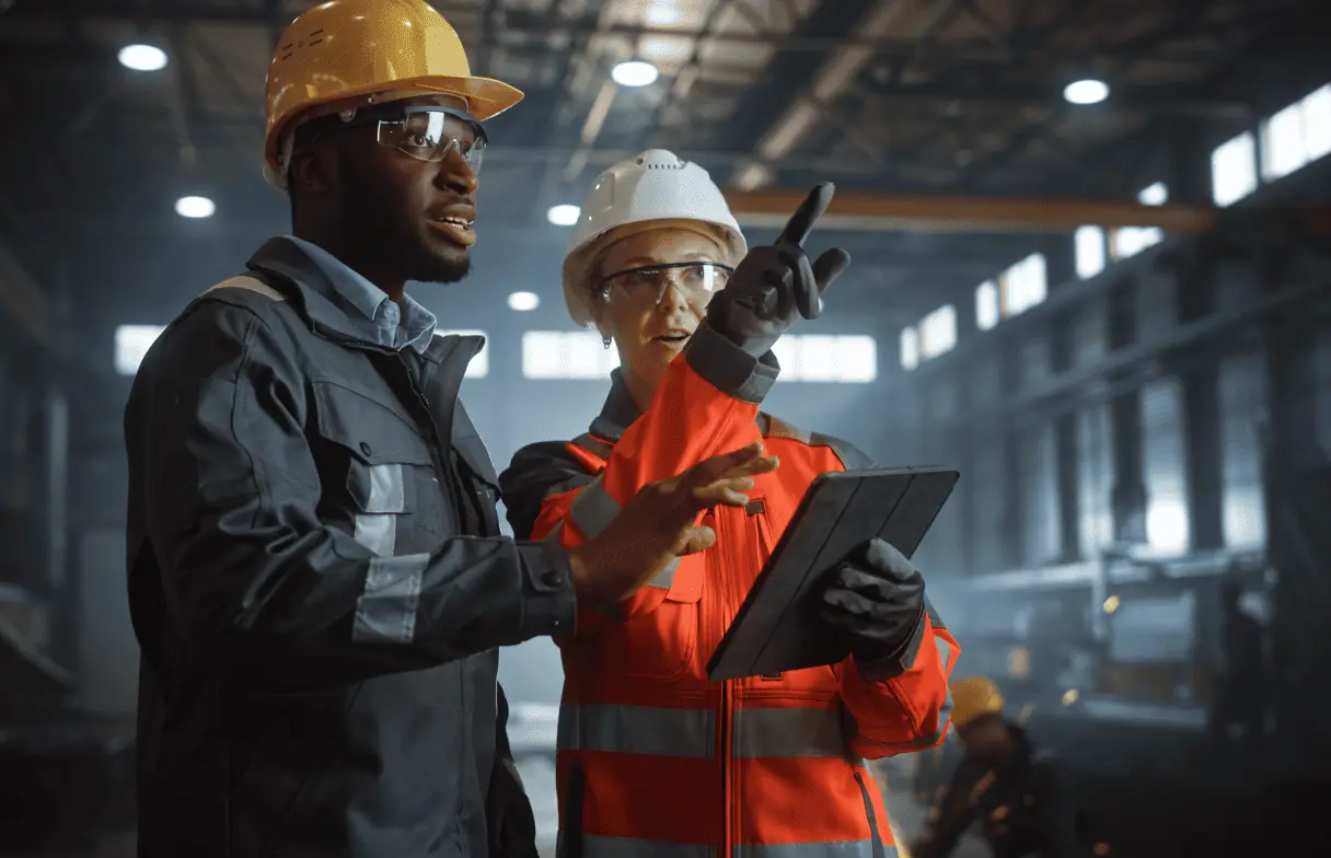 two deskless workers from manufacturing industry collaborating on the shop floor