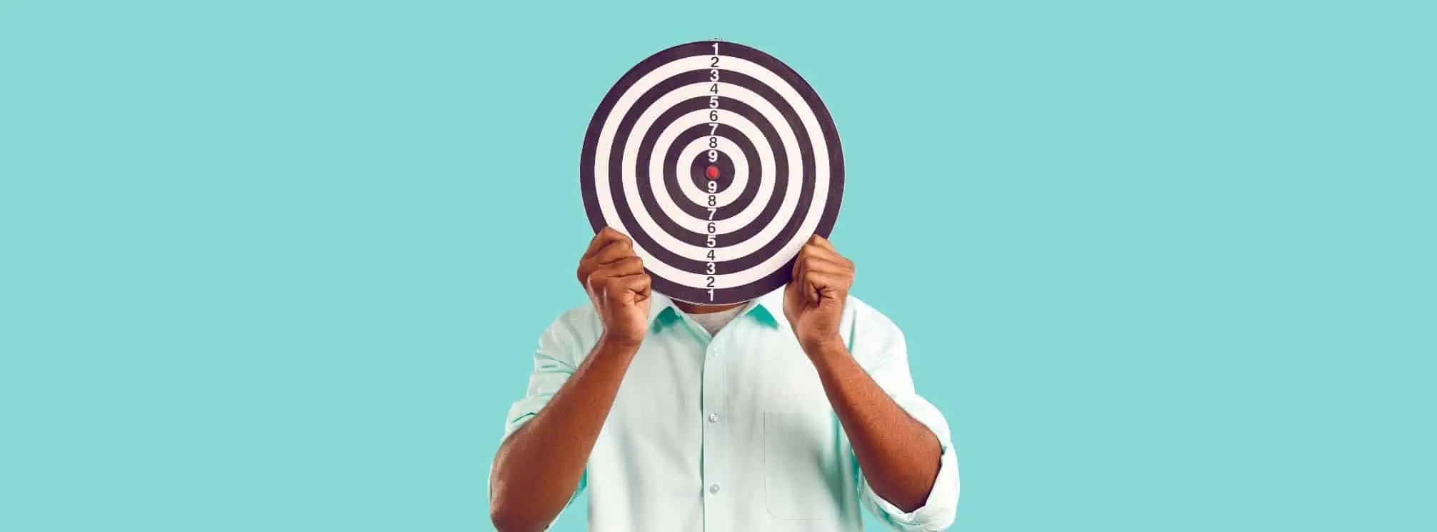 man holding a target board in front of his face