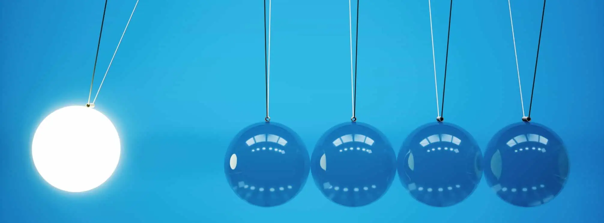 All blue image with one illuminated ball swinging out and about to come down on four other balls, to create a perpetual motion loop.