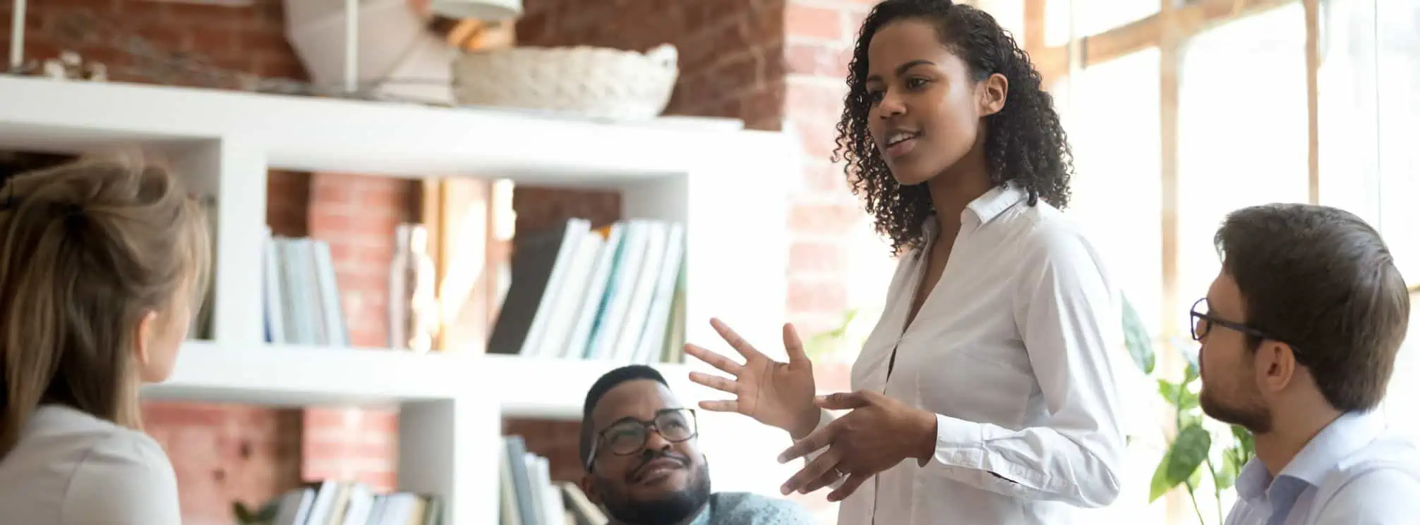 Black woman giving an engaging verbal communication presentation to colleagues