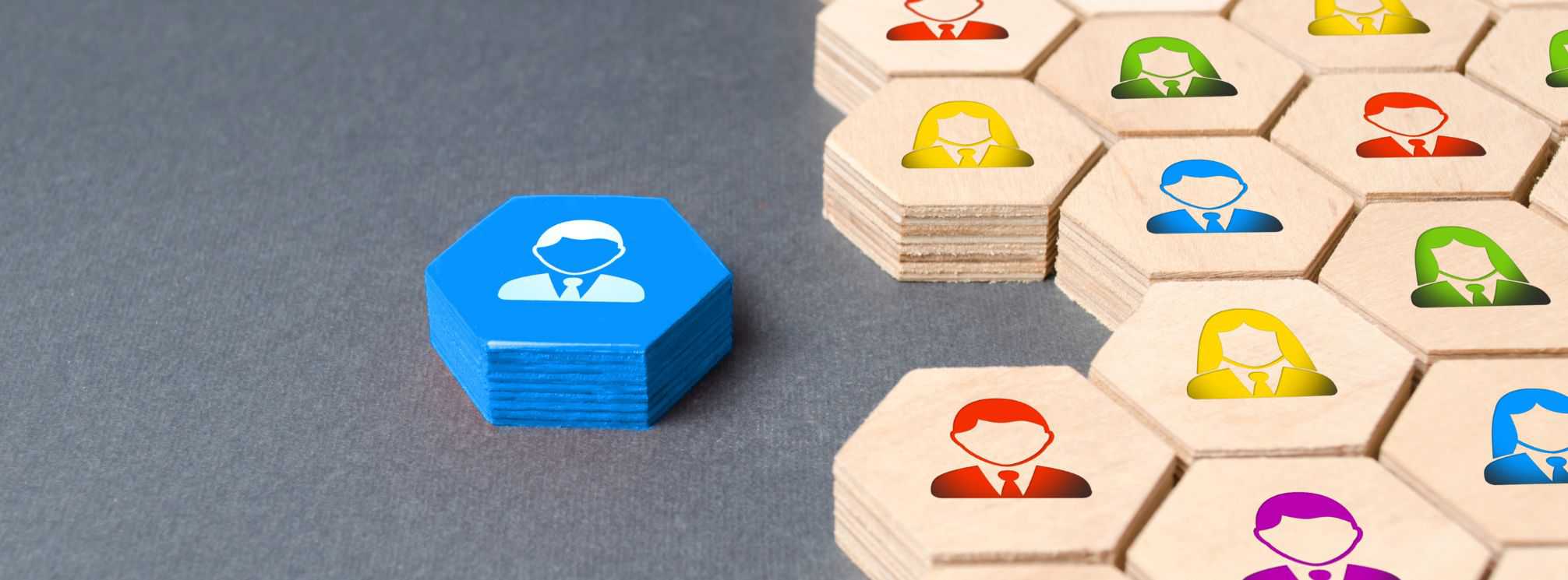 manager icon on a blue wooden block next to a matrix of multicolor people icons on wood blocks