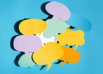 mass text employees represented by a pile of speech bubbles cut out of colorful construction paper on a blue gradient background