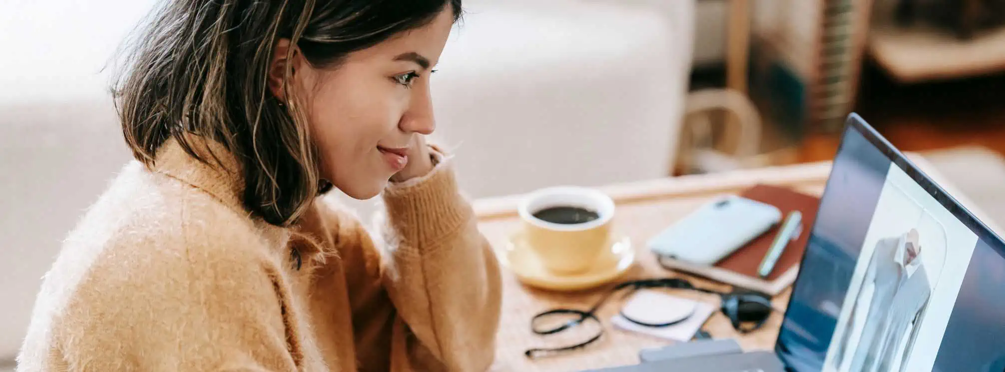 remote employee working from home on her laptop with a cup of coffee