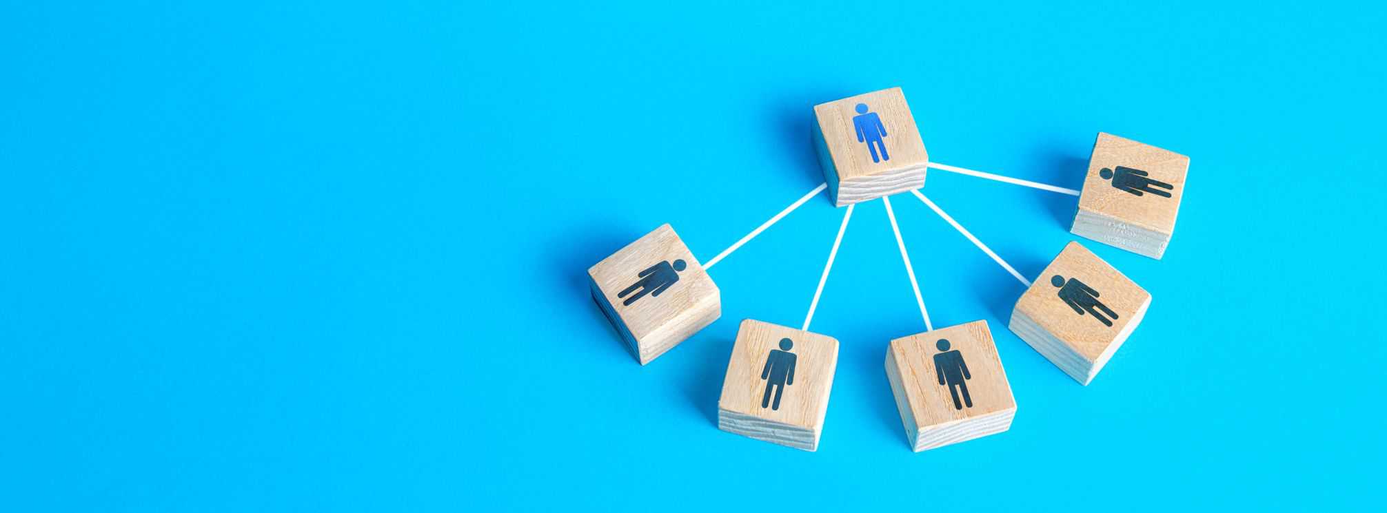 wooden blocks with people icons on them arranged with five connecting into one. This represents a manager and their direct reports.
