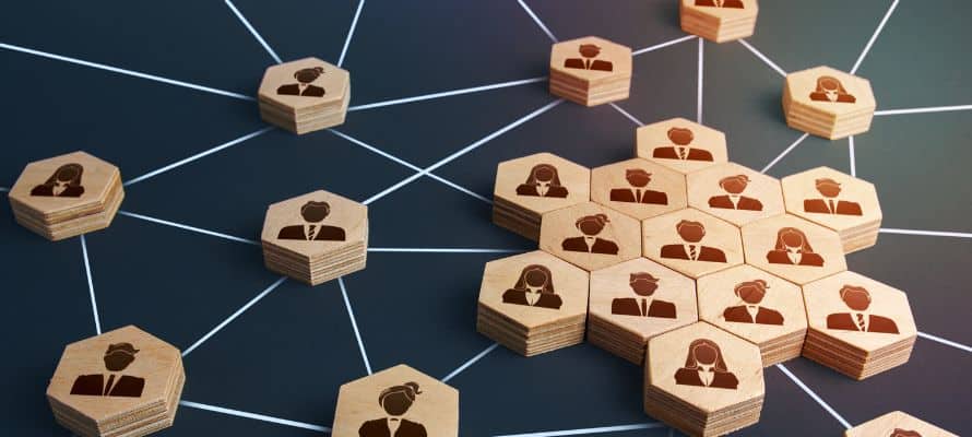 Employee relations represented by a matrix of wooden blocks with business people icons on them connected by a matrix of lines