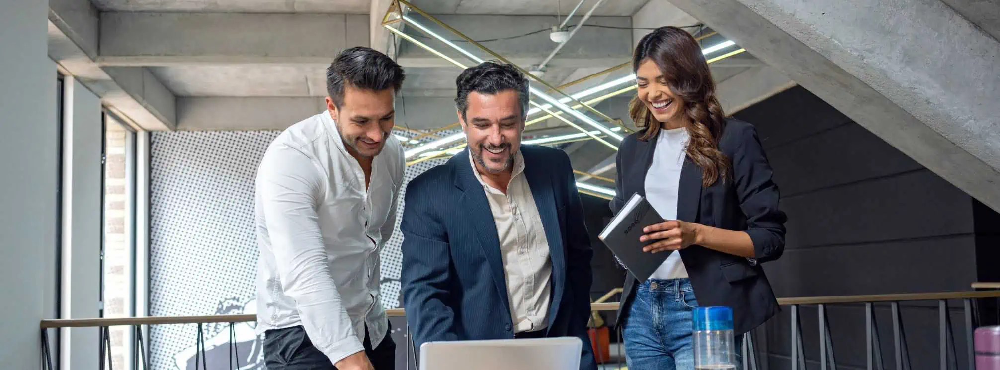 three professionals, two men and one woman, happily working together