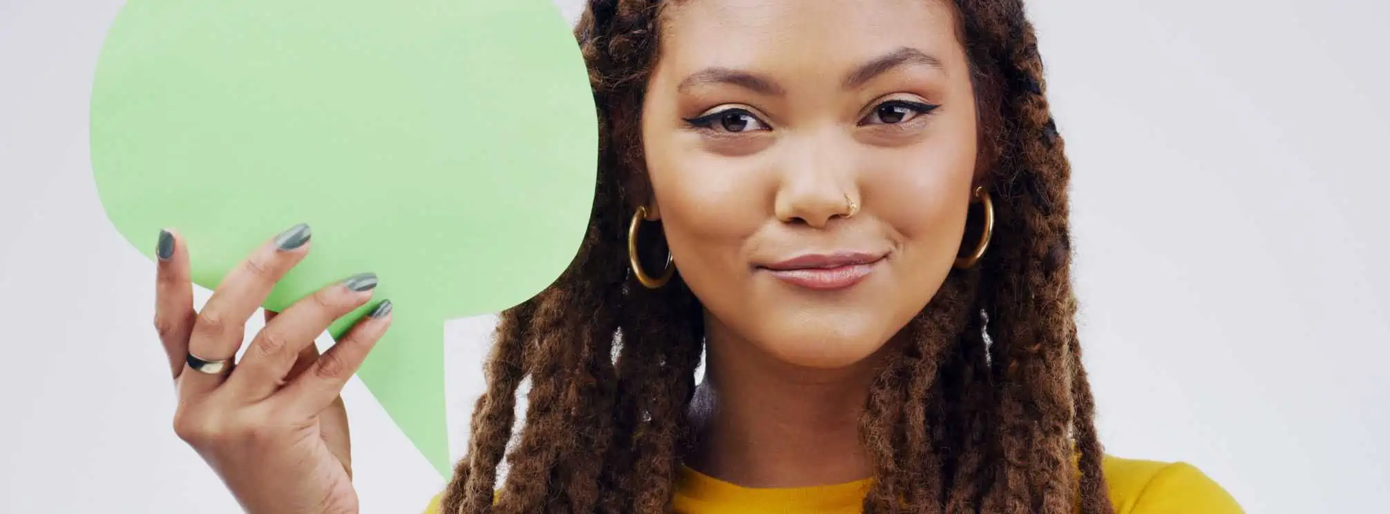 Young black woman holding a green paper cutout of a speech bubble