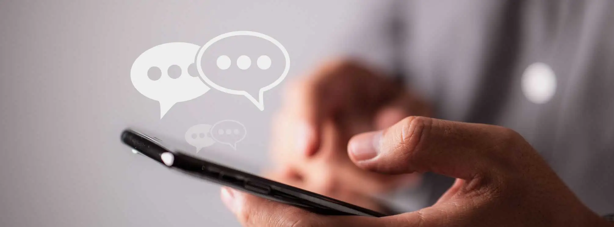 man texting on his smartphone with text bubble icons floating above the phone