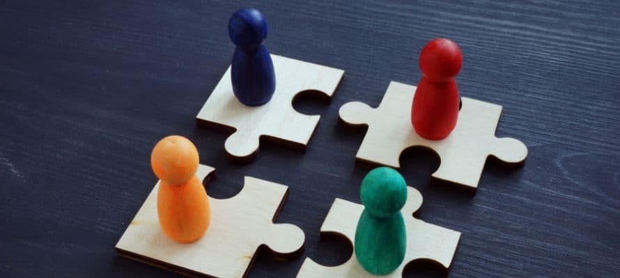Labor relations represented by four puzzle pieces coming together with a different colored wood peg on top of each