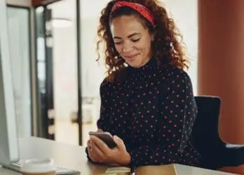 female professional at her desk receiving text messages for internal communication purposes