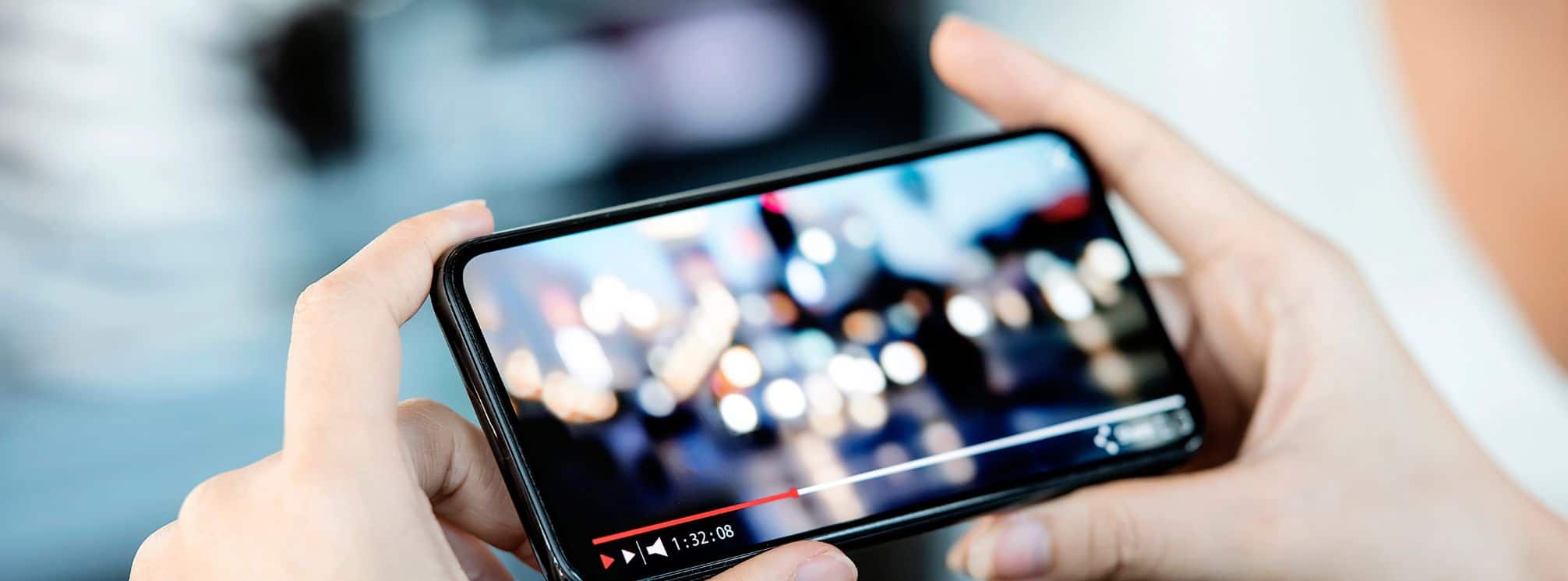 hands holding a smartphone with a video playing on it